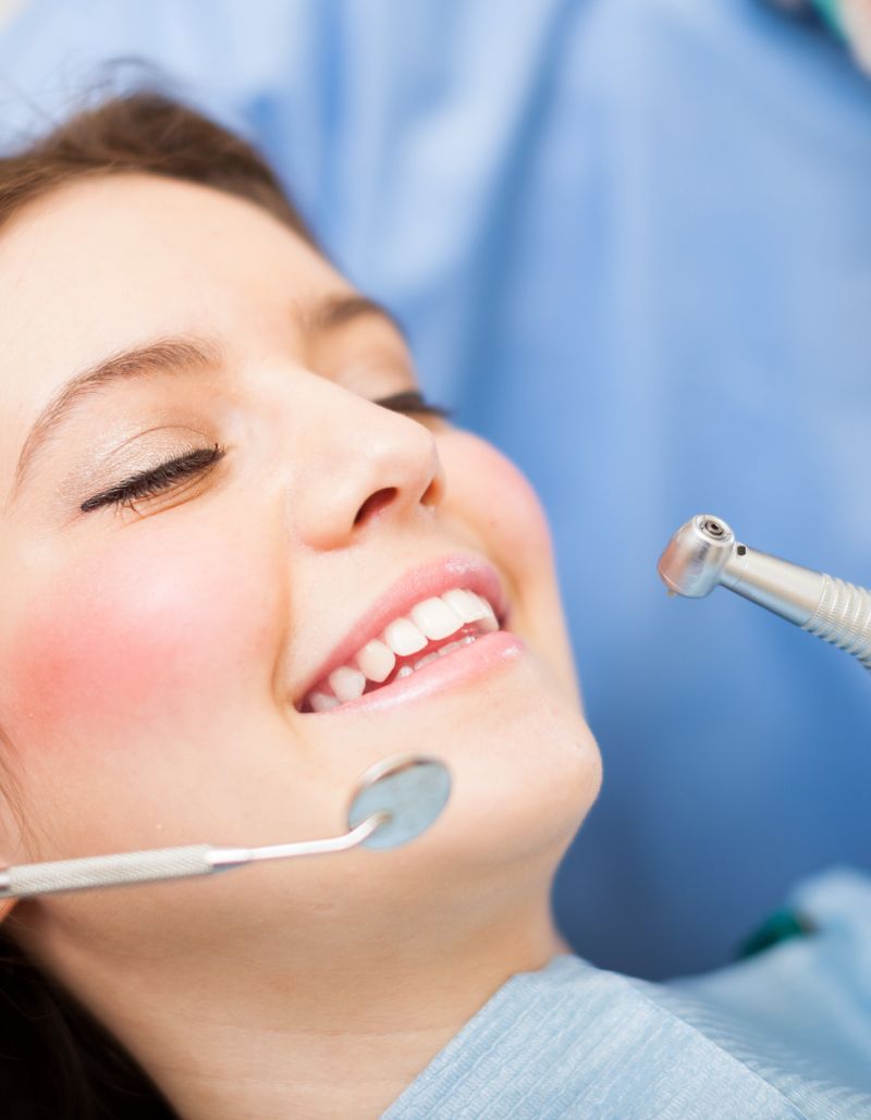 Chica sonriente recibiendo tratamiento dental