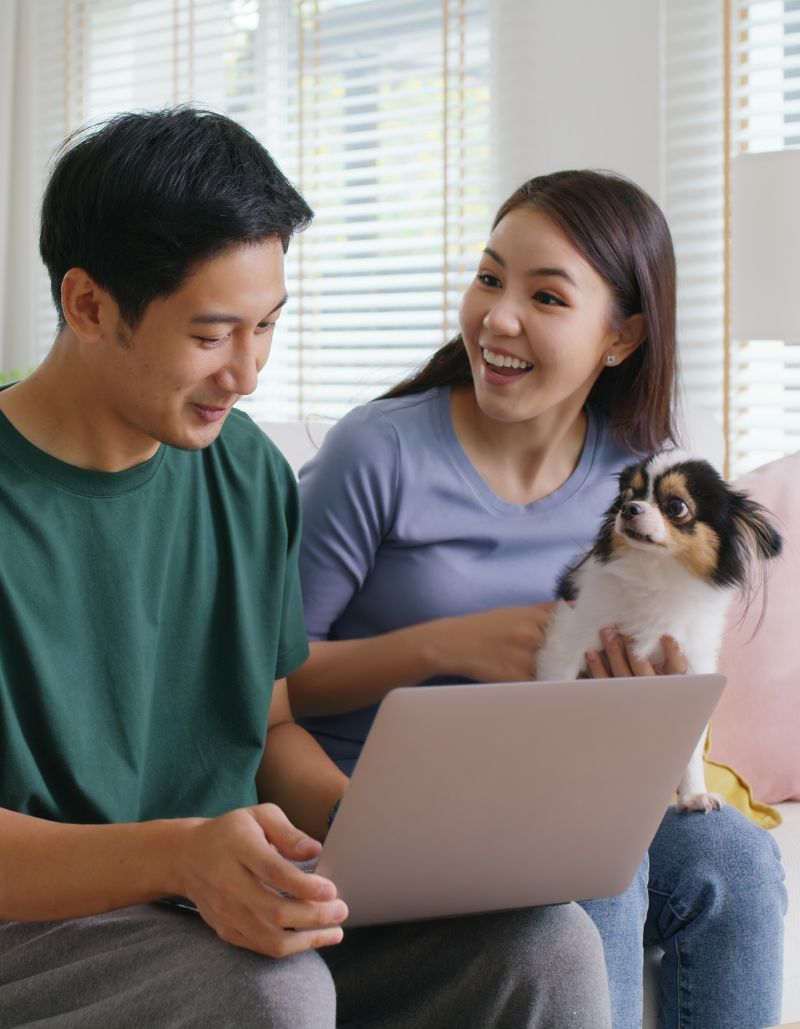 Pareja joven con su perro en brazos